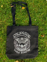 Load image into Gallery viewer, The Butterfly Tote has a butterfly in the center of the image whos body is a needle. There are flowers below the butterfly forming a half circle. The top part of the circle is formed by barbed wire. The words &quot;Southside&quot; are above the circle and &quot;Harm Reduction&quot; are below the circle. Image is on the black tote. 
